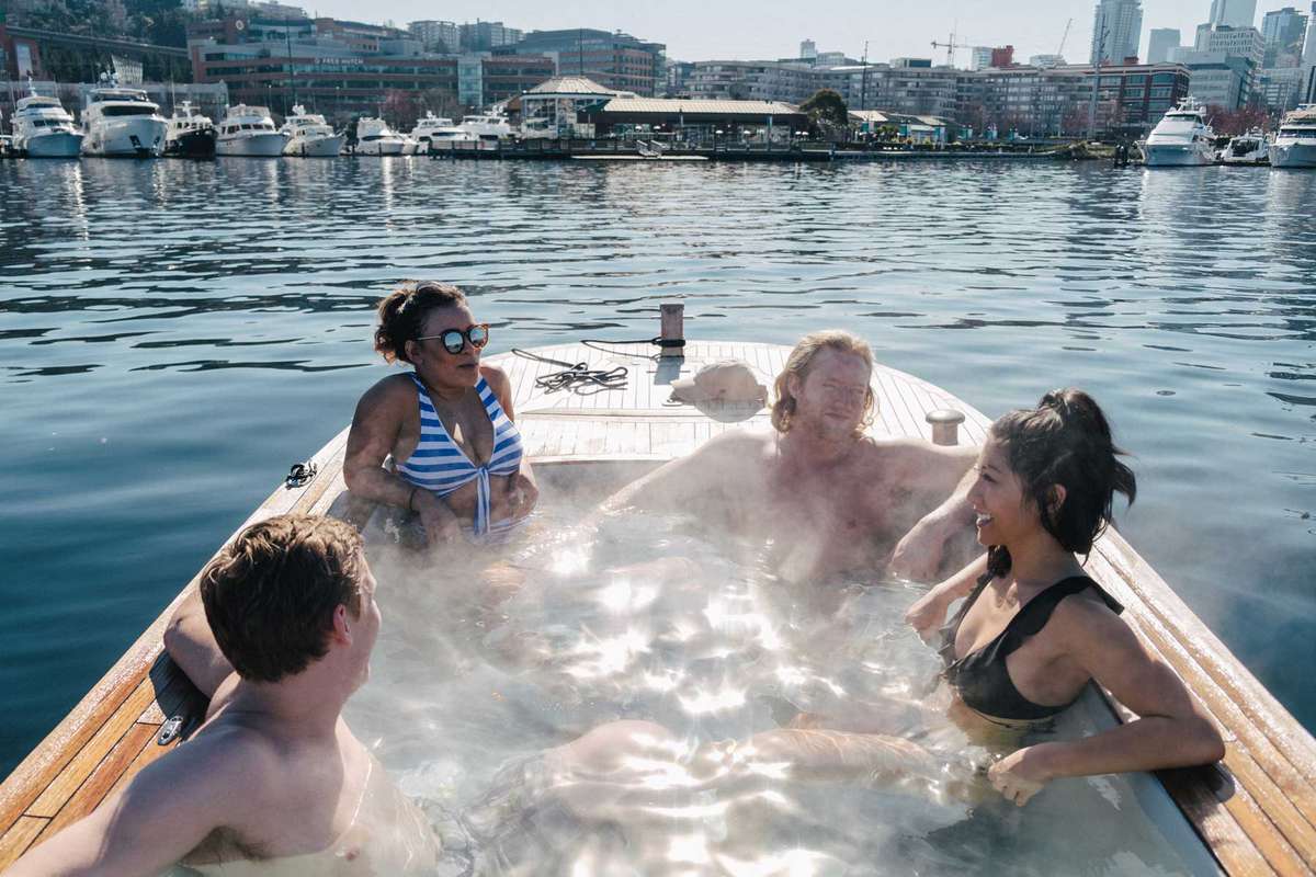 Four people in a hot tub in a boat on the waters of Seattle