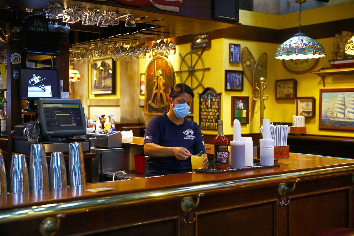 Eliana Barros, a bartender/server in Cheers, finishes a drink order at Quincy Market in Boston on July 1, 2020.