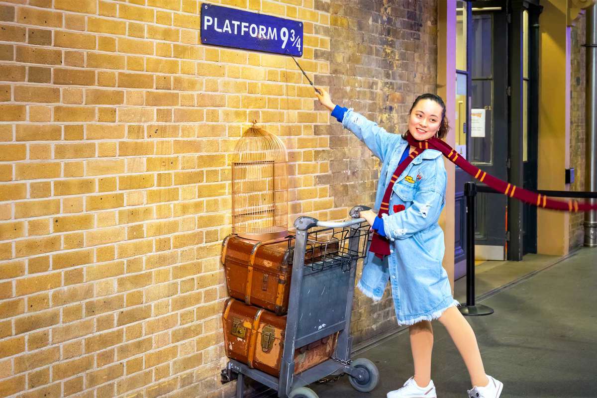 People at the platform 9 3/4 at King's Cross railway station in London, UK