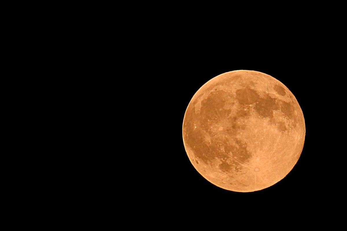 An orange "harvest moon" rises over Manassas, Virginia
