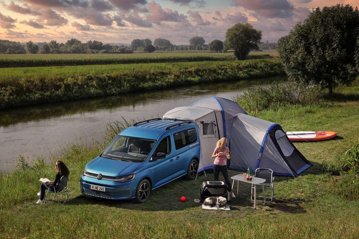 The 2021 Volkswagen California Caddy expands to be a campsite with tent near a river