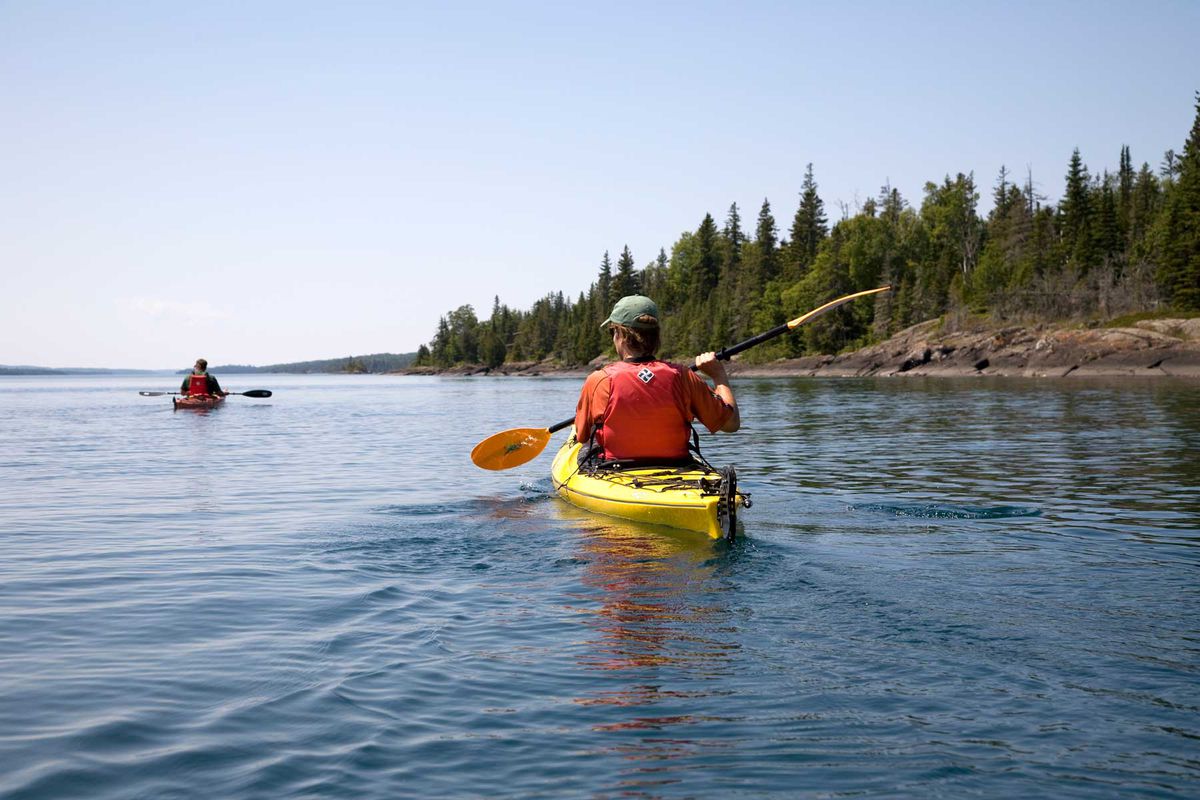 Two people kayaking on water near Isle Royale National Park