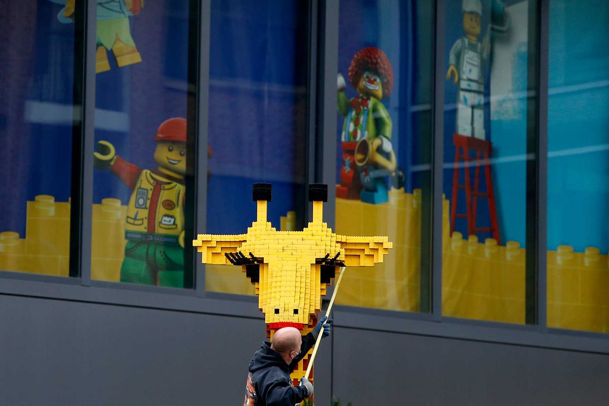 A worker measures the Lego Land mascot for a mask as retail shops remain closed in Assembly Square in Somerville, MA on May 12, 2020.