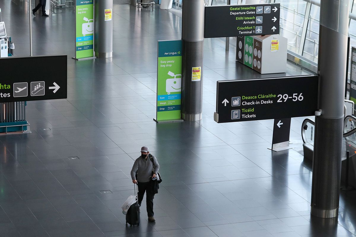 man wearing protective face mask walks through Terminal 2 in Dublin Airport