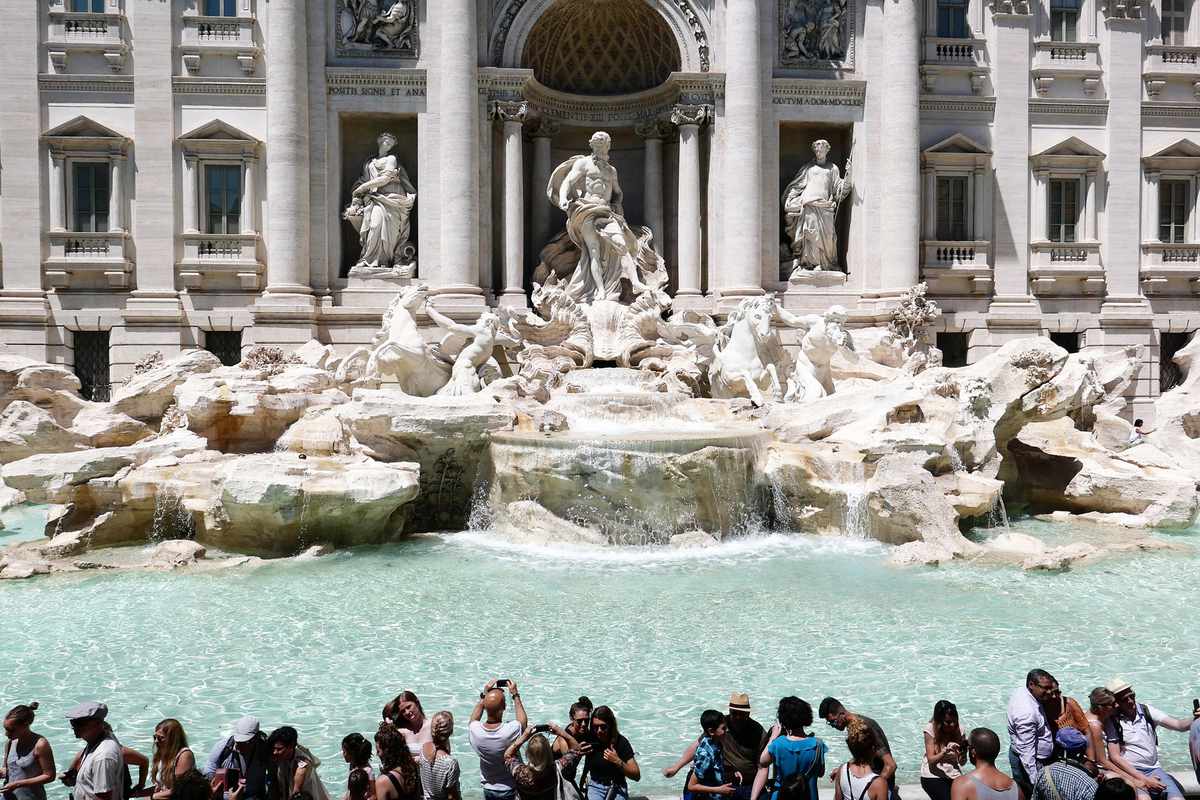 Tourists gather by the Trevi Fountain during an unusually early summer heatwave on June 24, 2019 in Rome