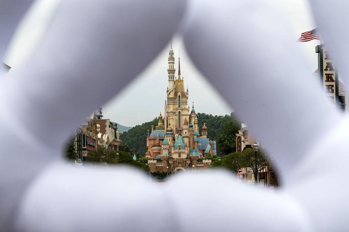 Mickey Mouse theme gloves as they make a triangle-shape hole displaying the iconic Disney castle at the Disneyland Resort in Hong Kong, China on September 25, 2020