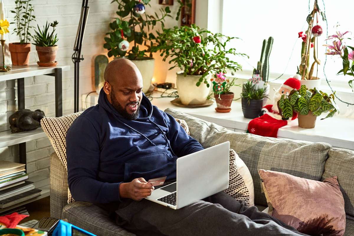 man sitting on a couch using a laptop
