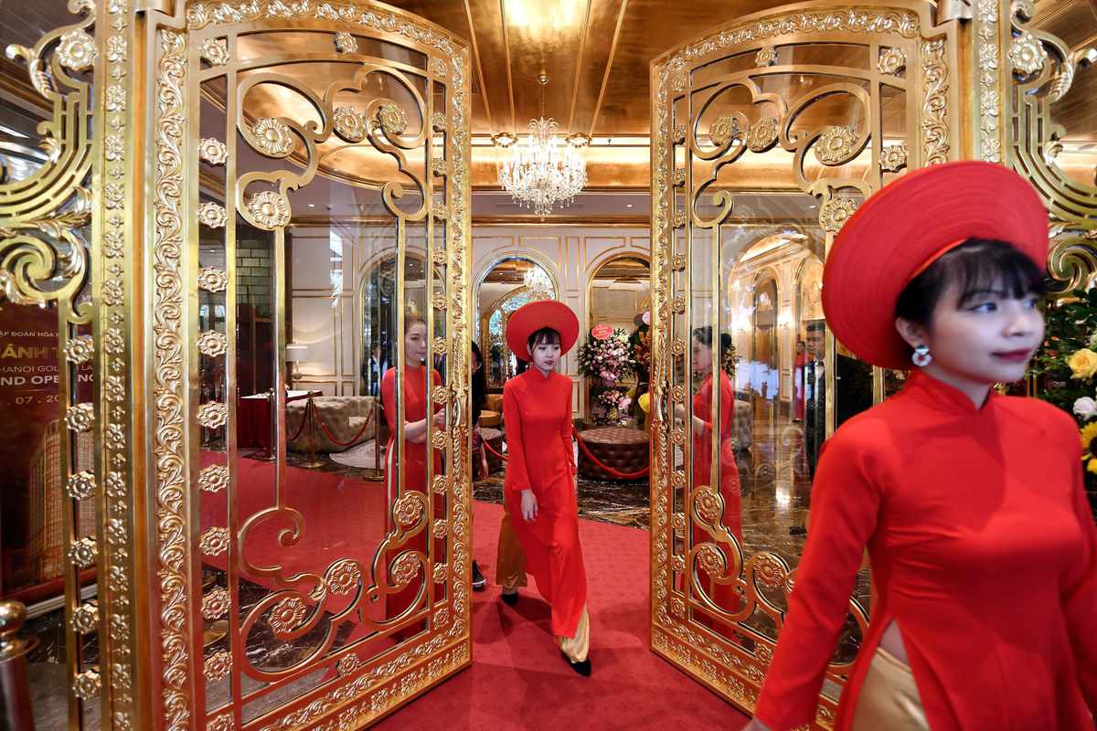 Staff wait to welcome guests in the lobby of the newly-inaugurated Dolce Hanoi Golden Lake hotel, the world's first gold-plated hotel, in Hanoi on July 2, 2020.