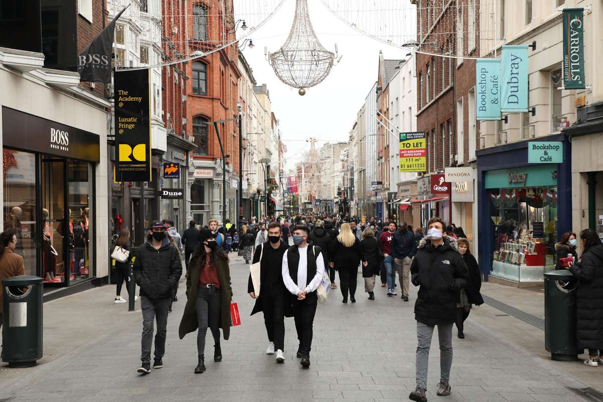 People walk in a shopping area in Dublin, Ireland