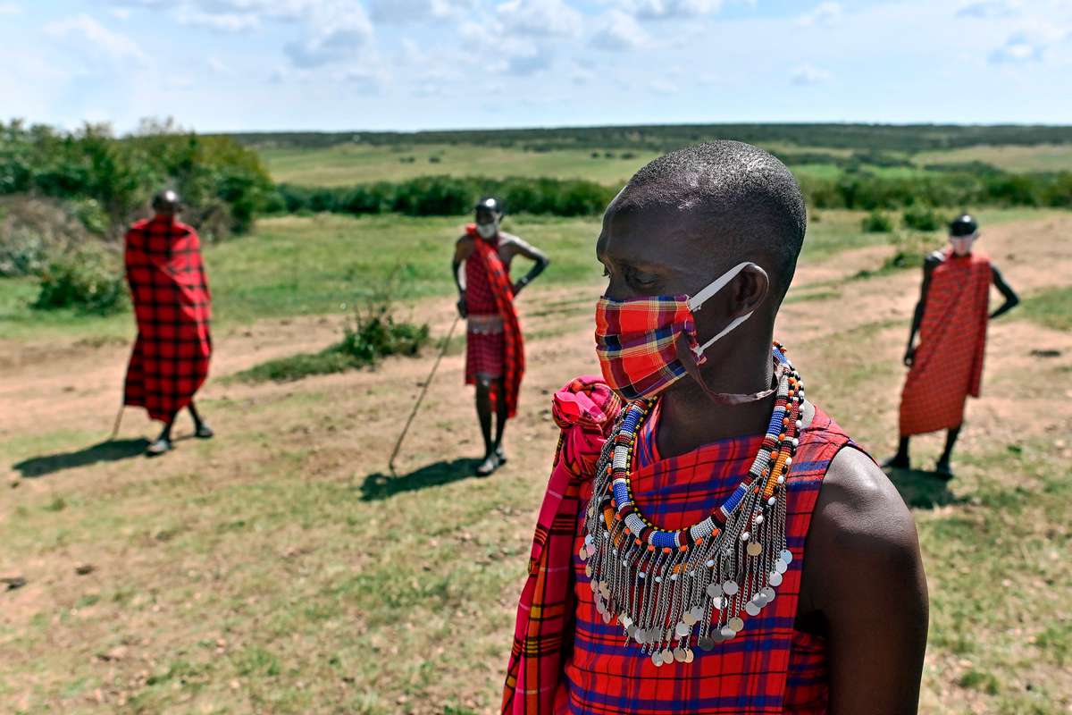 Cultural performers from the Maasai tribe wear cloth masks as they gather outside their manyatta (village) in Talek