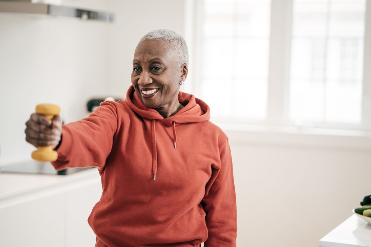 Senior women taking care of herself as she exercise with dumbbells at home