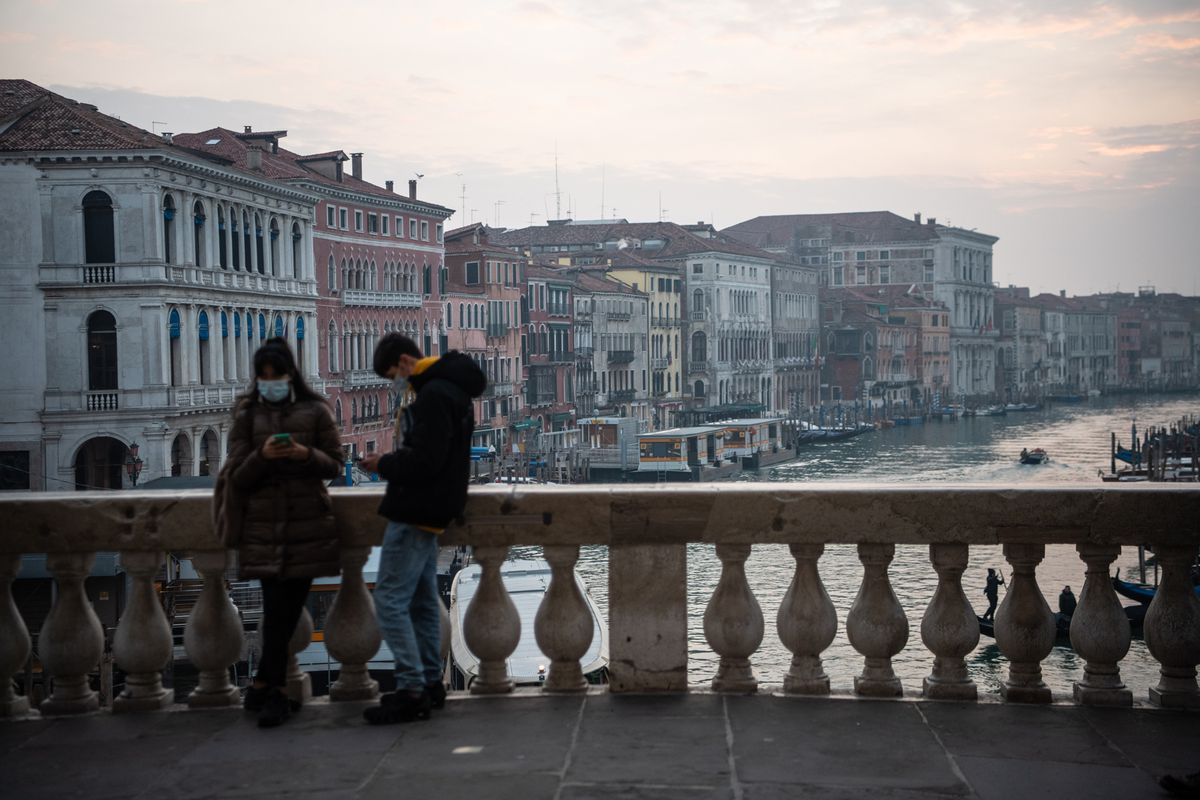 two people standing on Rialto Bridge in Venice, Italy