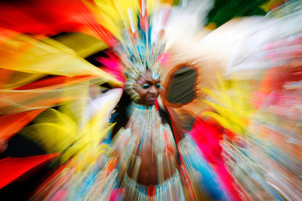 A performer at the Notting Hill Carnival, shown with motion blur