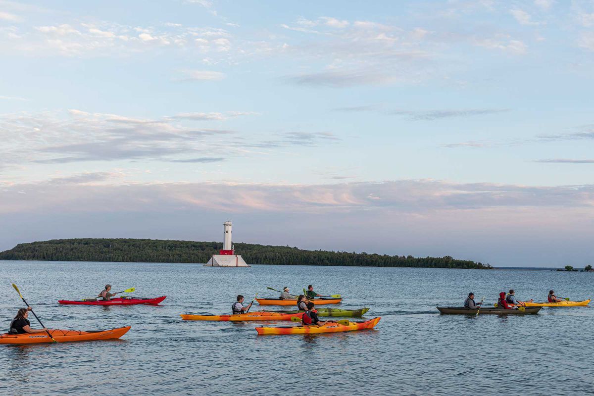 Scenes from Mackinac Island: orange kayaks on the water around Round Island