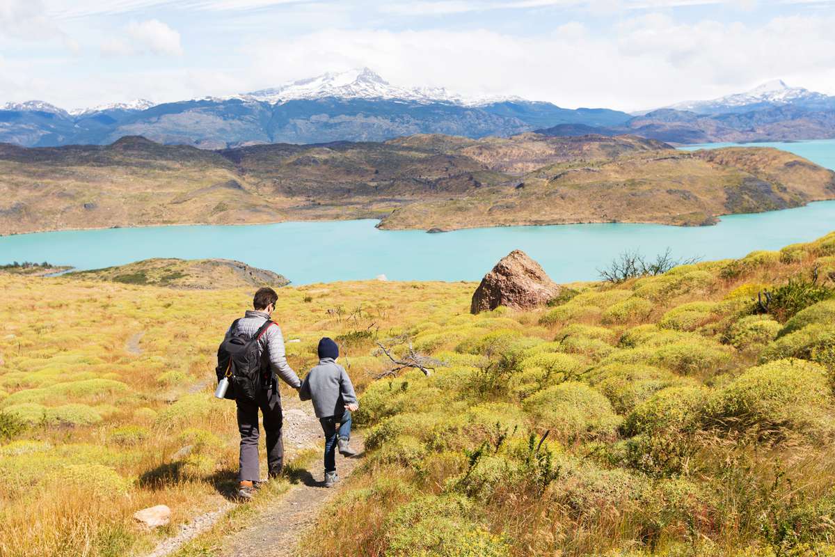 father and his son having adventure hike at torres del paine national park, patagonia, chile