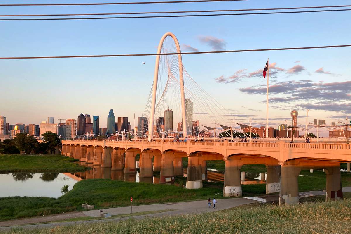 Sunset view of downtown Dallas and Margaret Hunt Hill bridge with the Ron C. Kirk Pedestrian bridge over the Trinity River.