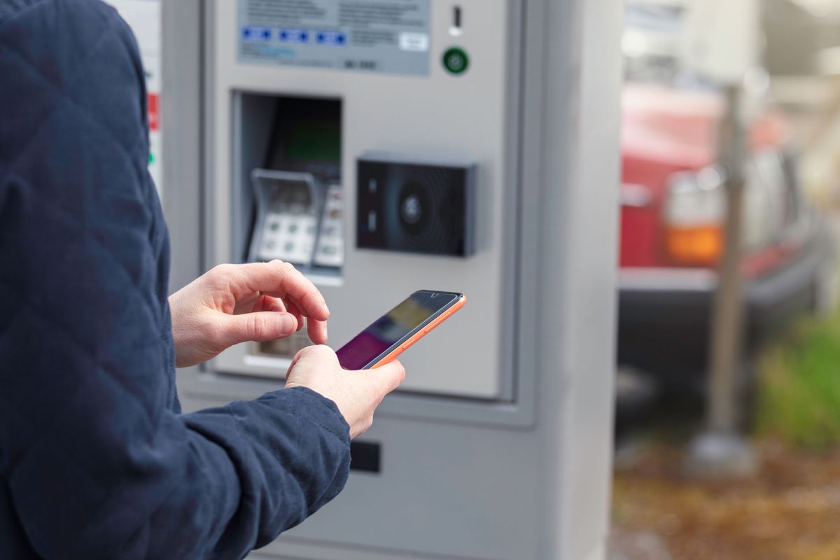 Closeup of a person paying for parking with a mobile phone