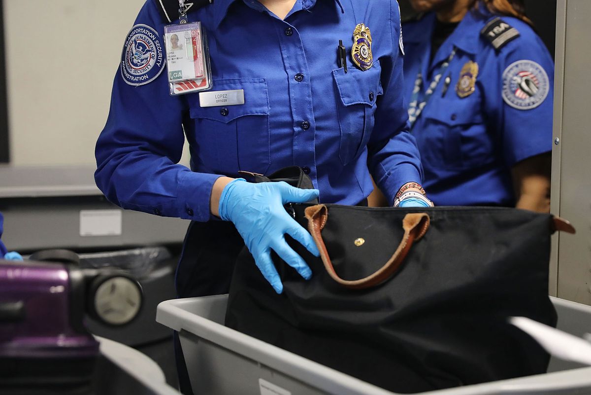 TSA worker screening luggage