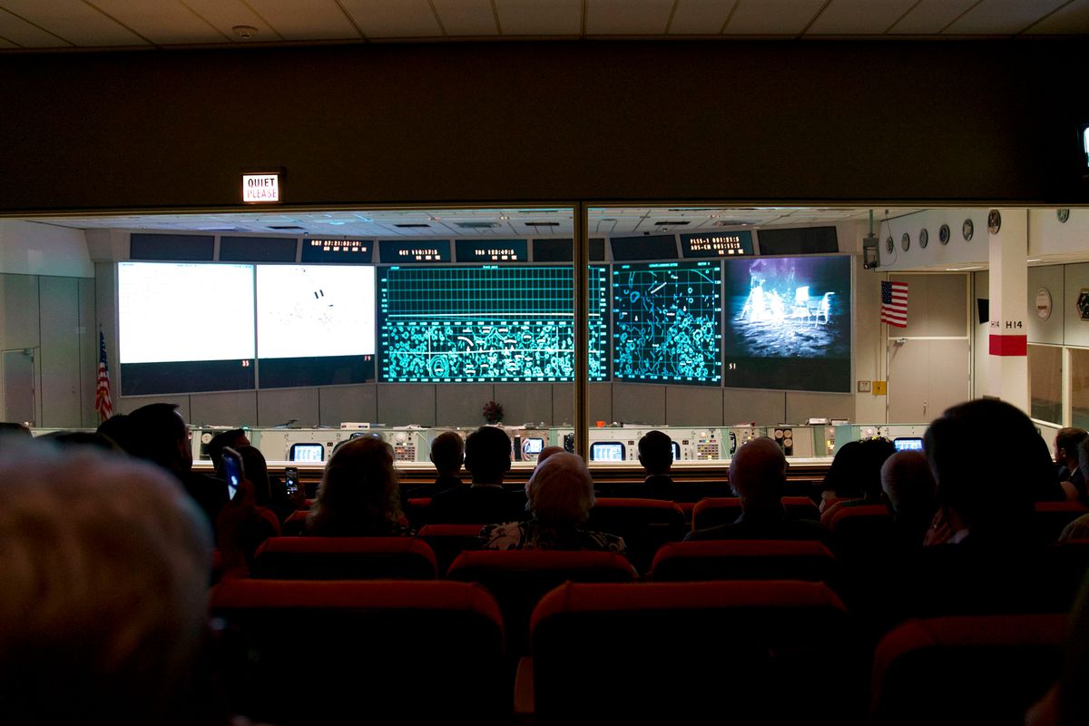 An audience views the recreation of the moon landing inside the newly restored Apollo Mission Control Room at NASA's Johnson Space Center