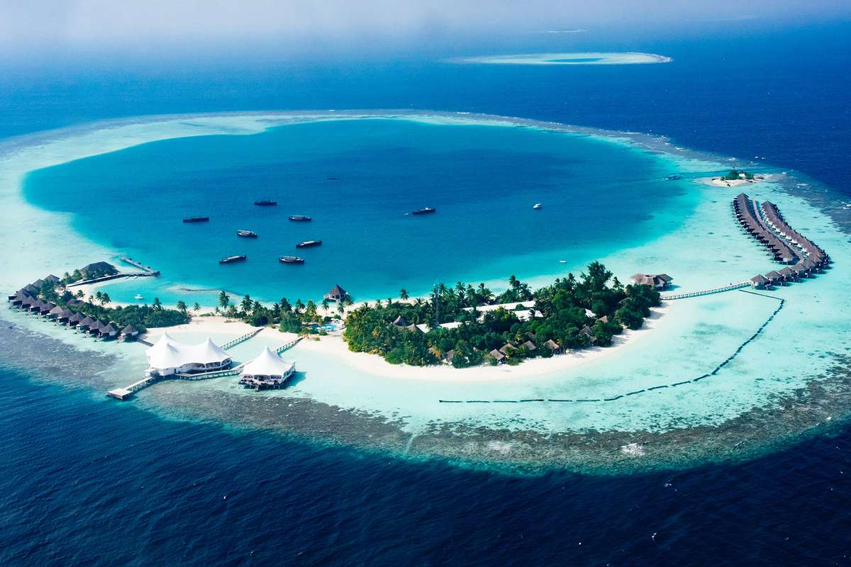 aerial view of blue waters and small island in the maldives