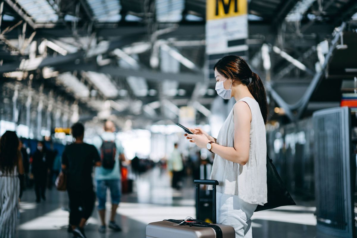 woman at airport using cell phone