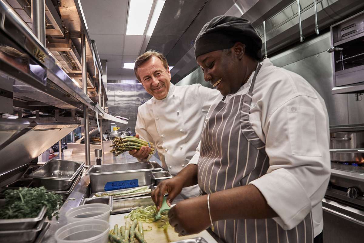 Chef Daneil Boulud and employee in the kitchen