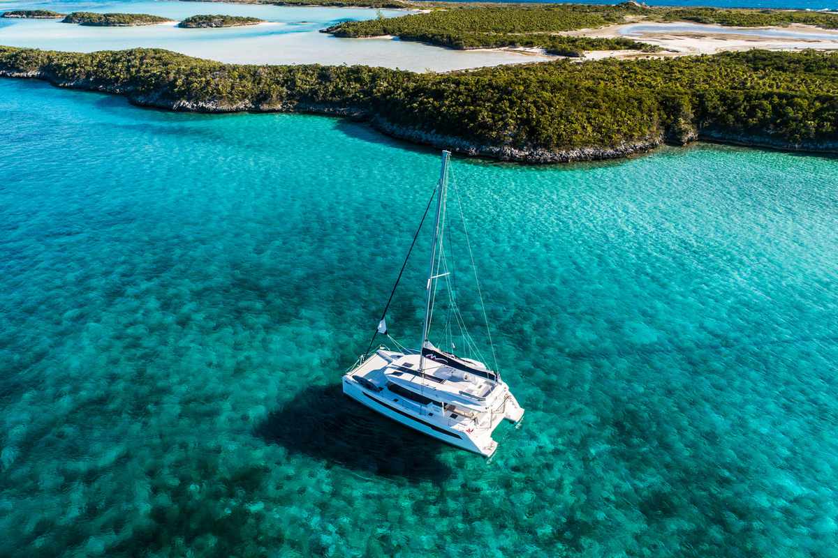 Sailing yacht on turquoise waters off of islands
