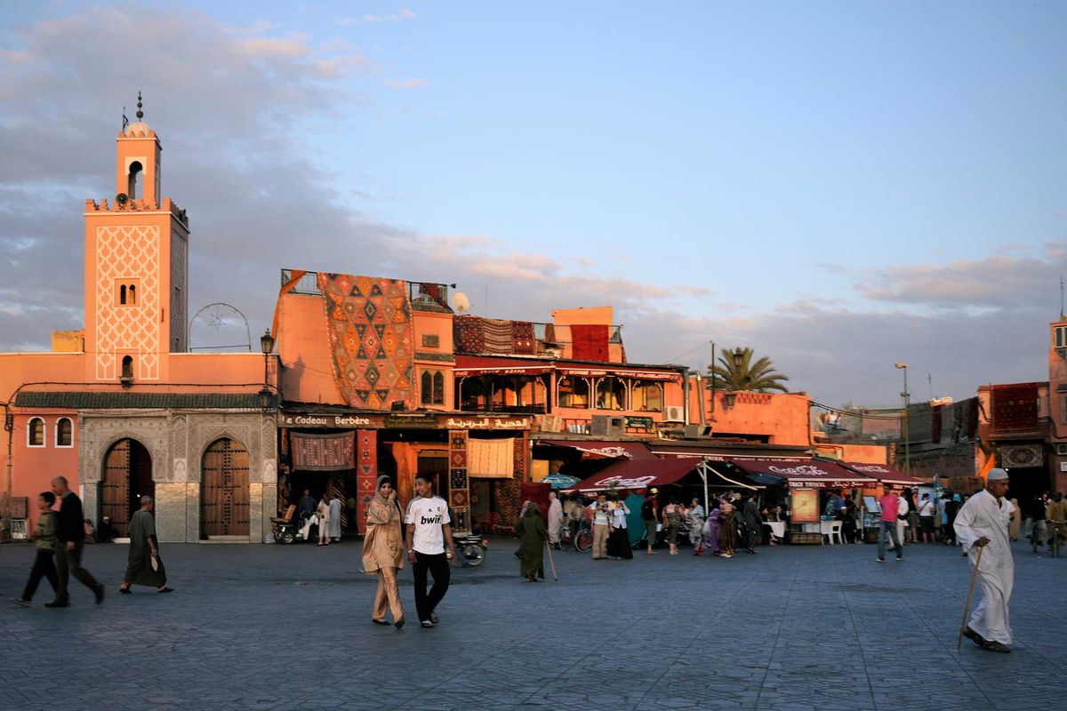 People at Djemaa el-Fna Square in Marrakesh during the sunset.