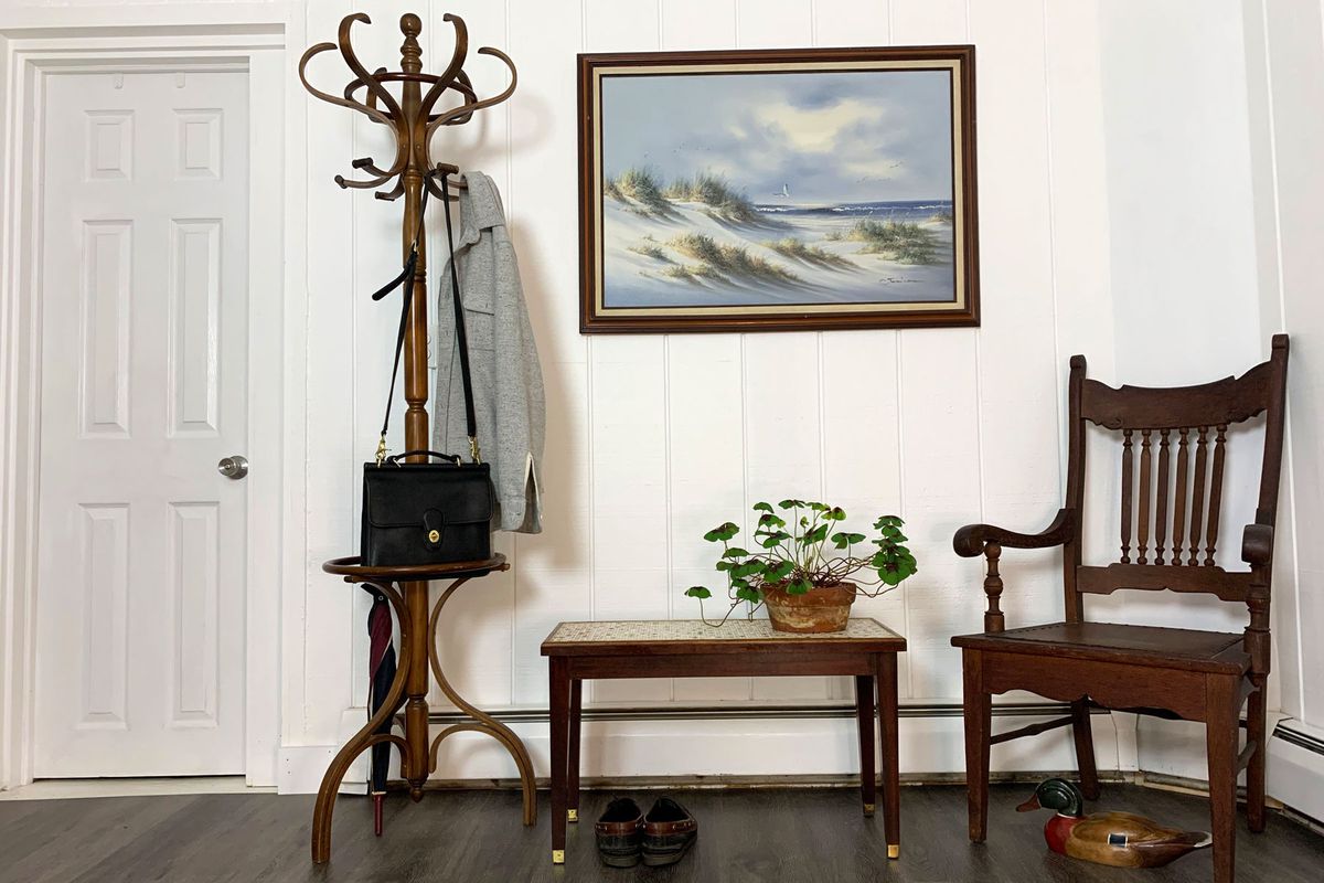 Airbnb entryway with bench, wooden chair, coat rack