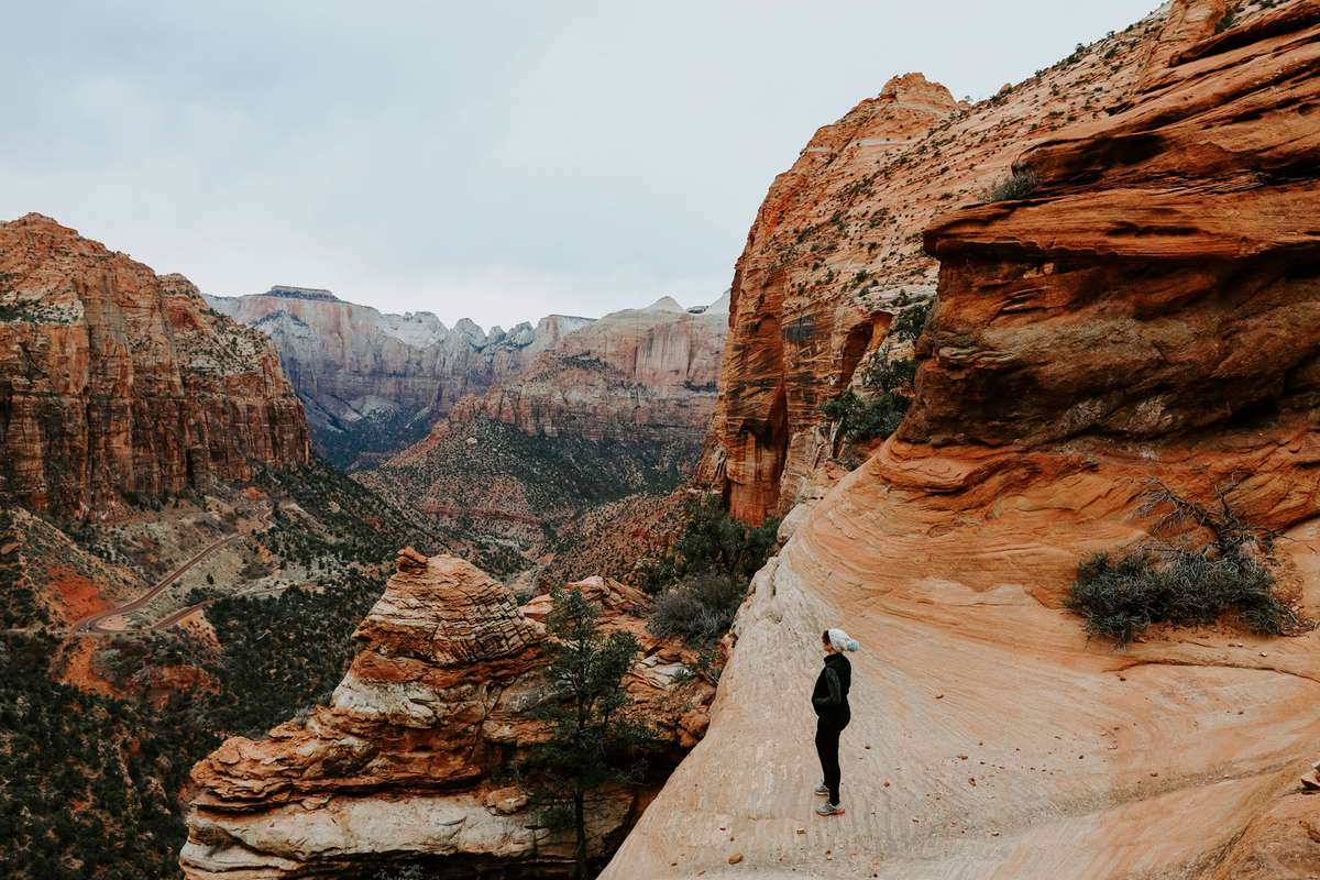 female hiker standing on rock formation at Zion National Park
