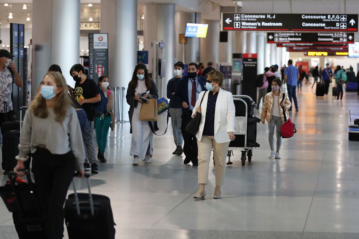 Travelers walk through Miami International Airport
