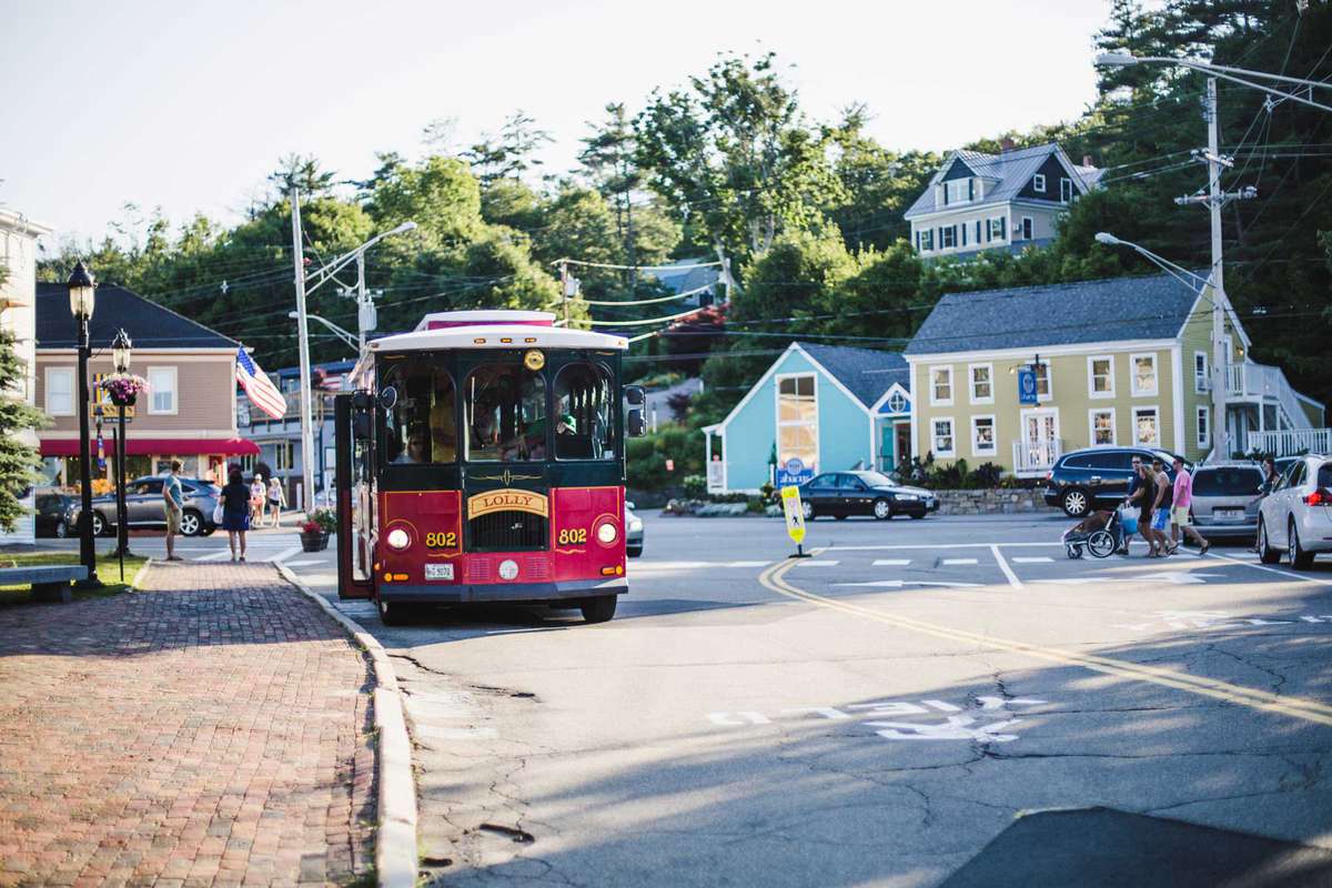 Vintage bus, people walking and cars in the street of Ogunquit, a pretty village on the east coa