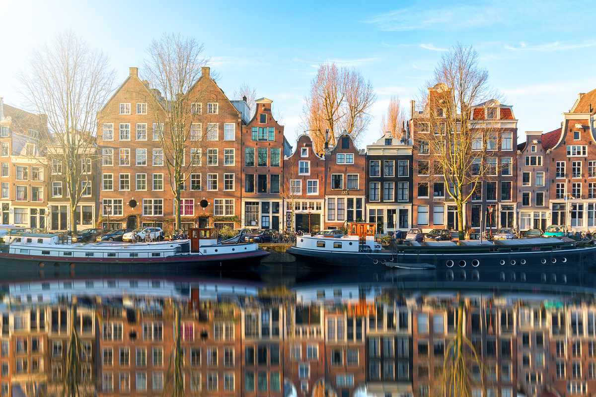 Morning reflections of homes in a canal in Amsterdam