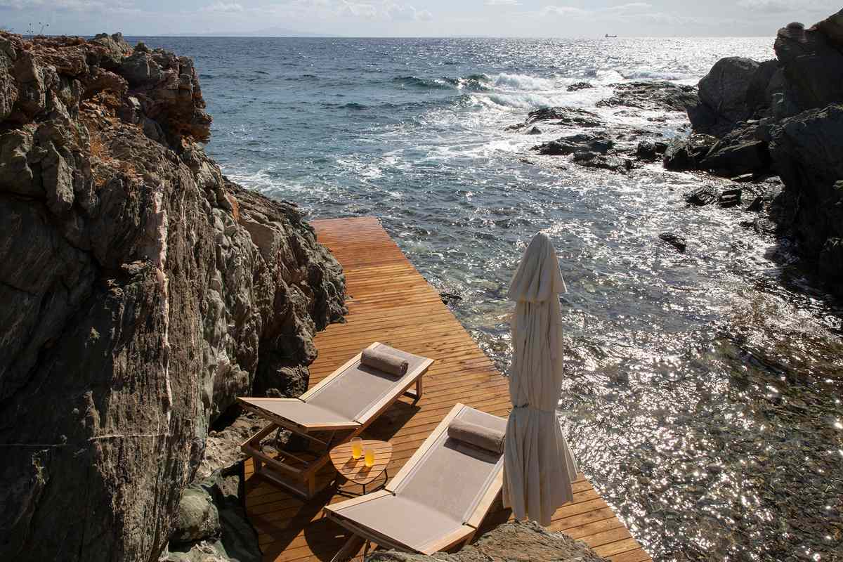 Lounge chairs by the ocean at Villa Fanya in Syros, a part of White Key Villas