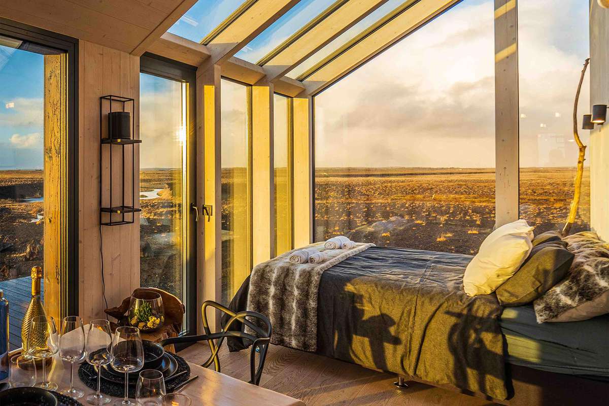 The bed and view from inside the glass home in Iceland