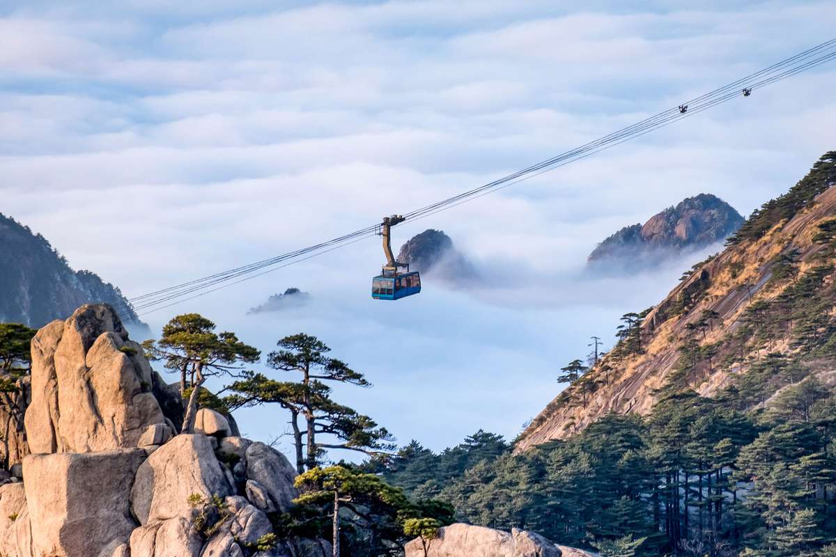 Scenic view of Huangshan yellow mountain cliffs in China from lift cable car and a lot of the mist in the winter season,