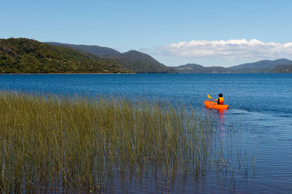 Woman kayaking on Lake Cucao in Cucao Chiloe National Park