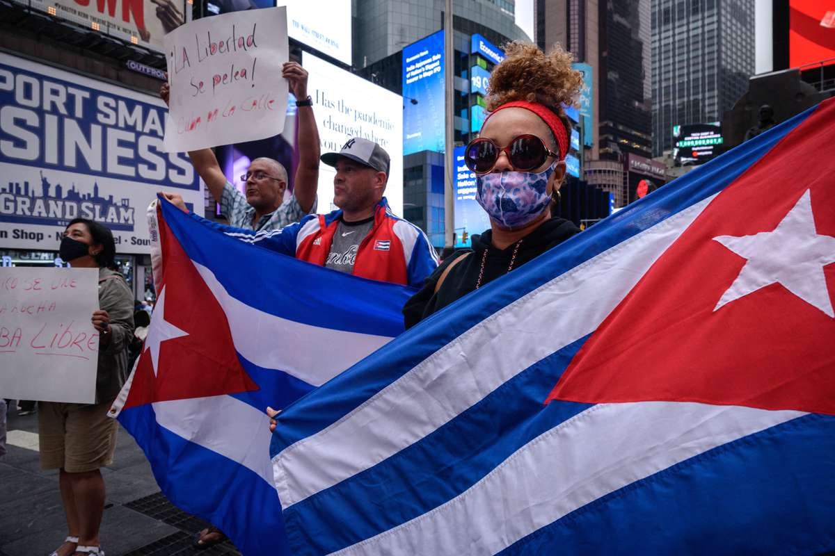 Demonstrators hold placards during a rally held in solidarity with anti-government protests in Cuba, in Times Square, New York on July 13, 2021.