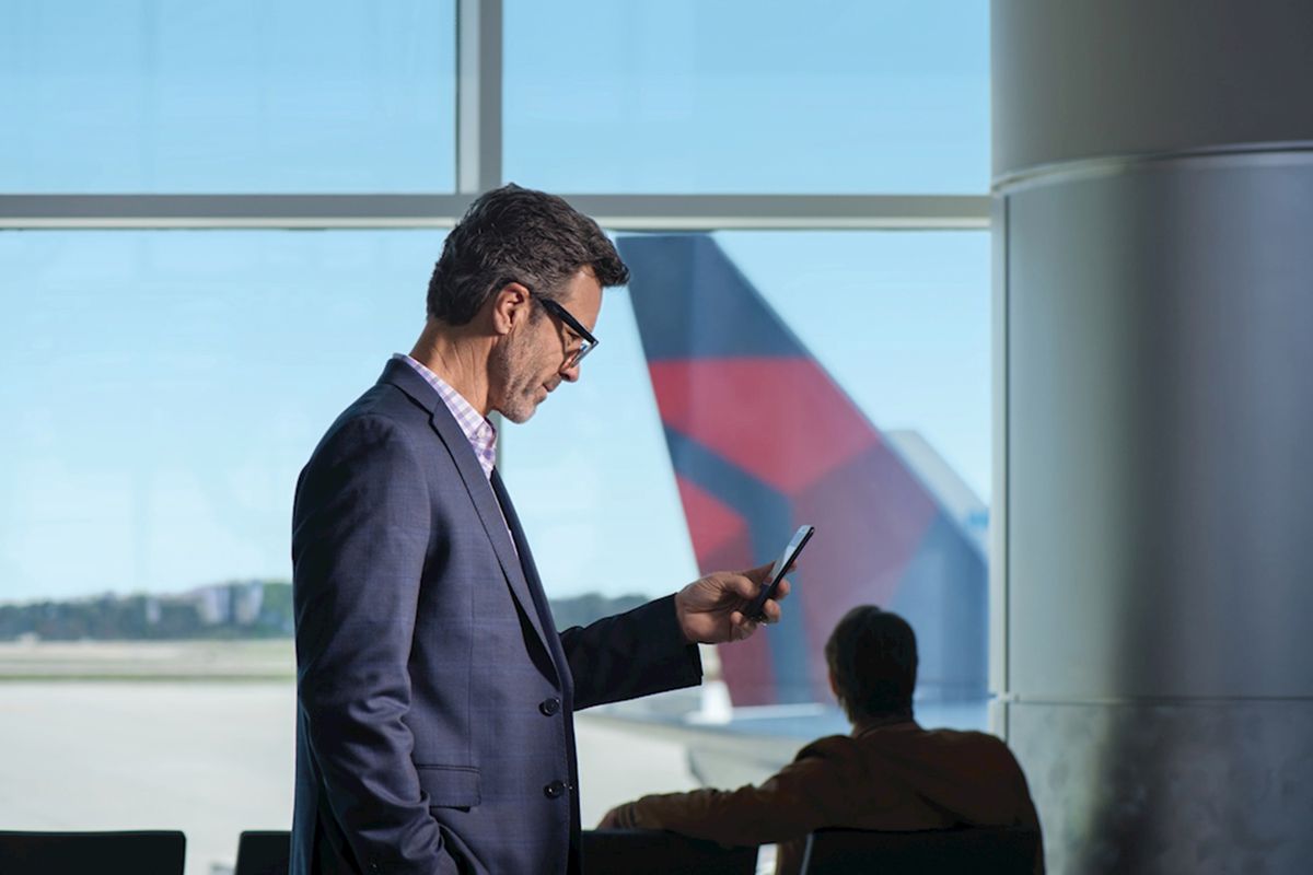 A man using the fly delta app in an airport