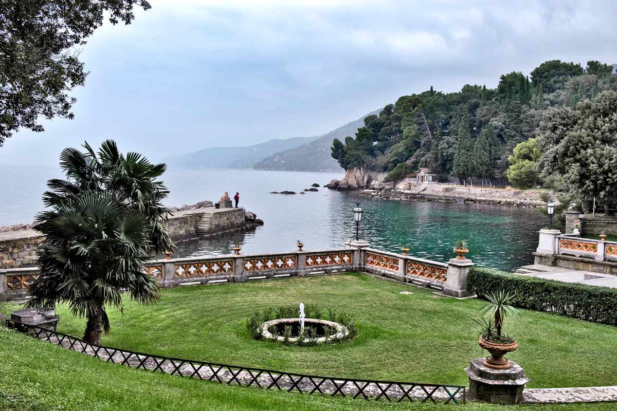 View of a garden in a public park and the bay of Trieste adjoining the Miramare castle in Trieste, Italy.