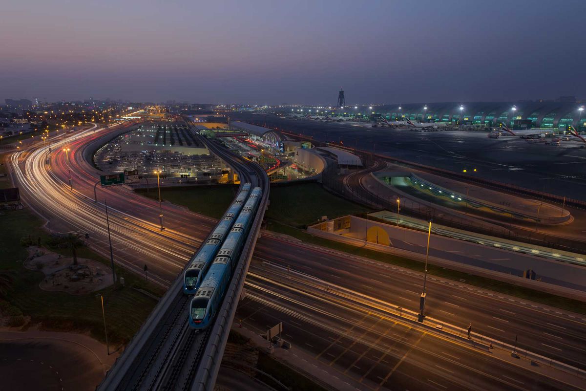 Dubai Airport, Dubai Metro trains and Highway at night