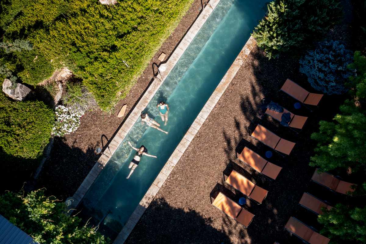 Three people swim in pool at Ojo Santa Fe Spa