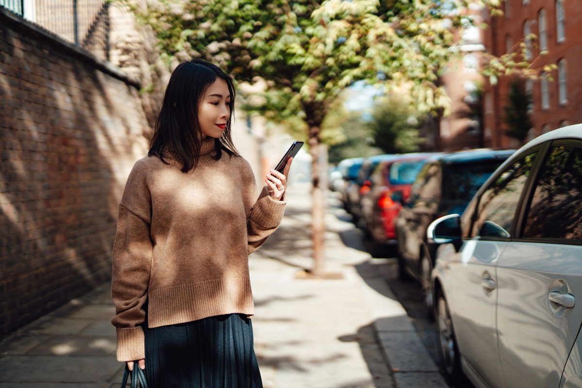 Asian woman looking for car on phone app