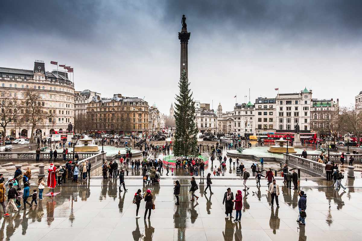 Tourists by the Christmas Tree in Trafalgar Square, London, UK