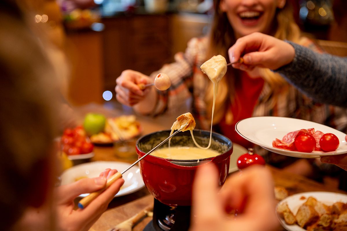 A group of people eat fondue together