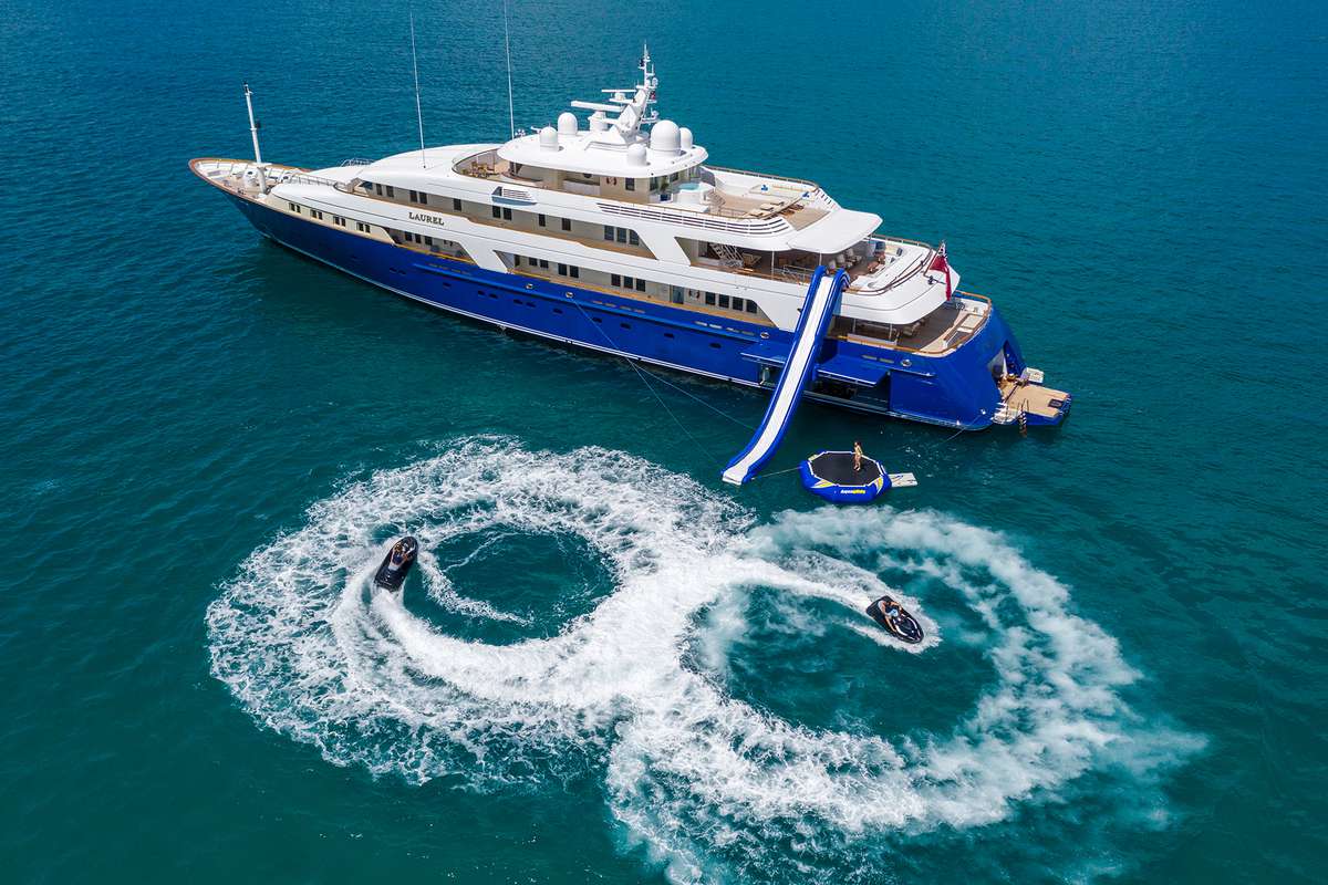 Aerial ofa IYC superyacht with guest riding jetskis