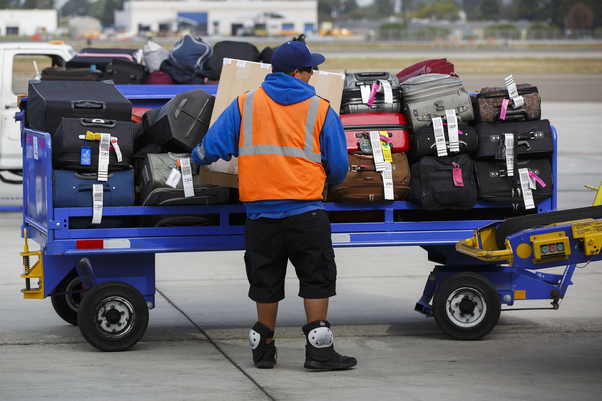 A ground operations employee loads baggage onto a Southwest Airlines Co. Boeing Co. 737 aircraft on the tarmac at John Wayne Airport (SNA) in Santa Ana, California