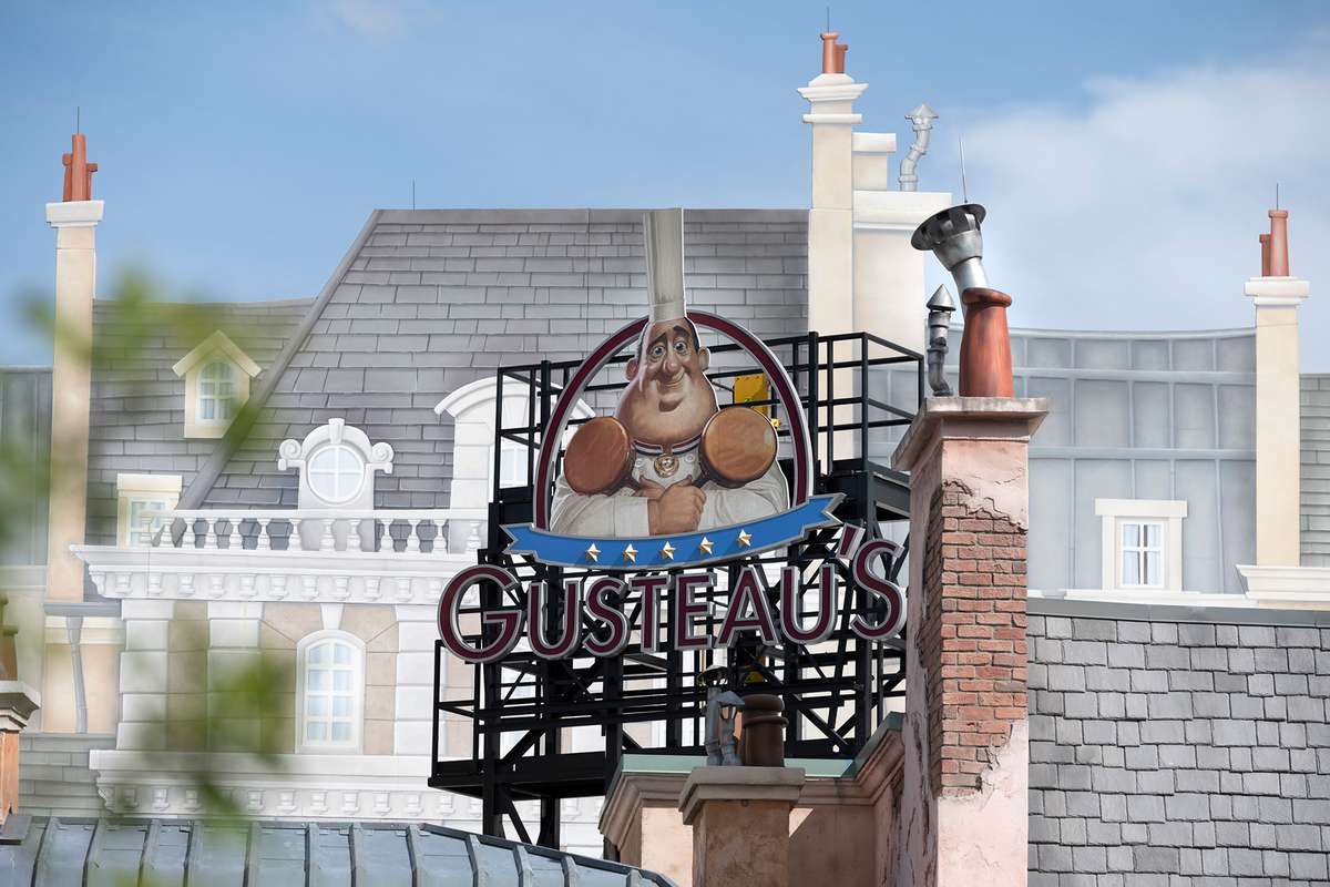 Gusteau’s restaurant sign hangs past the Remy’s Ratatouille Adventure attraction in the newly expanded France pavilion at EPCOT at Walt Disney World Resort in Lake Buena Vista, Fla.