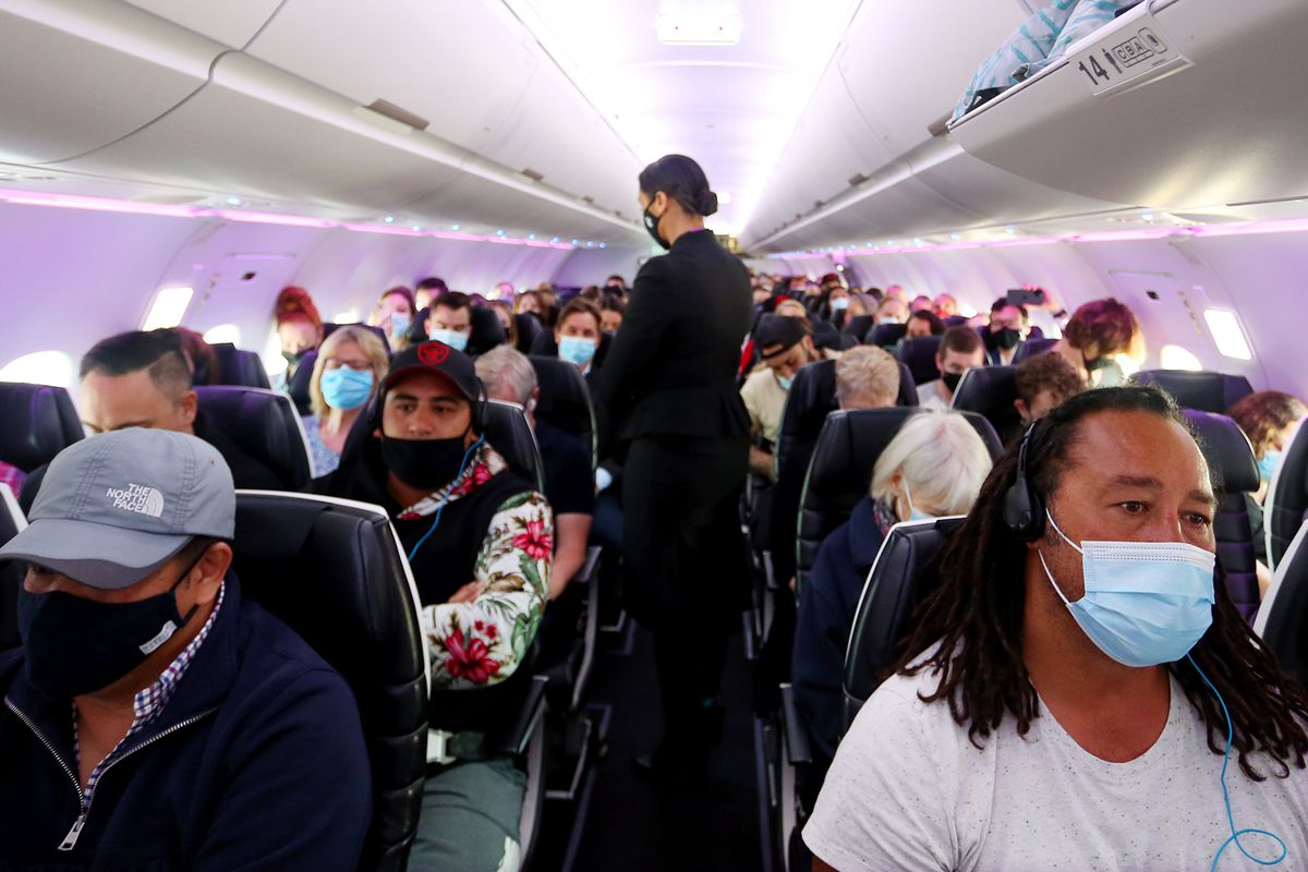Passengers are seen boarding Air New Zealand flight number 246 destined for Wellington