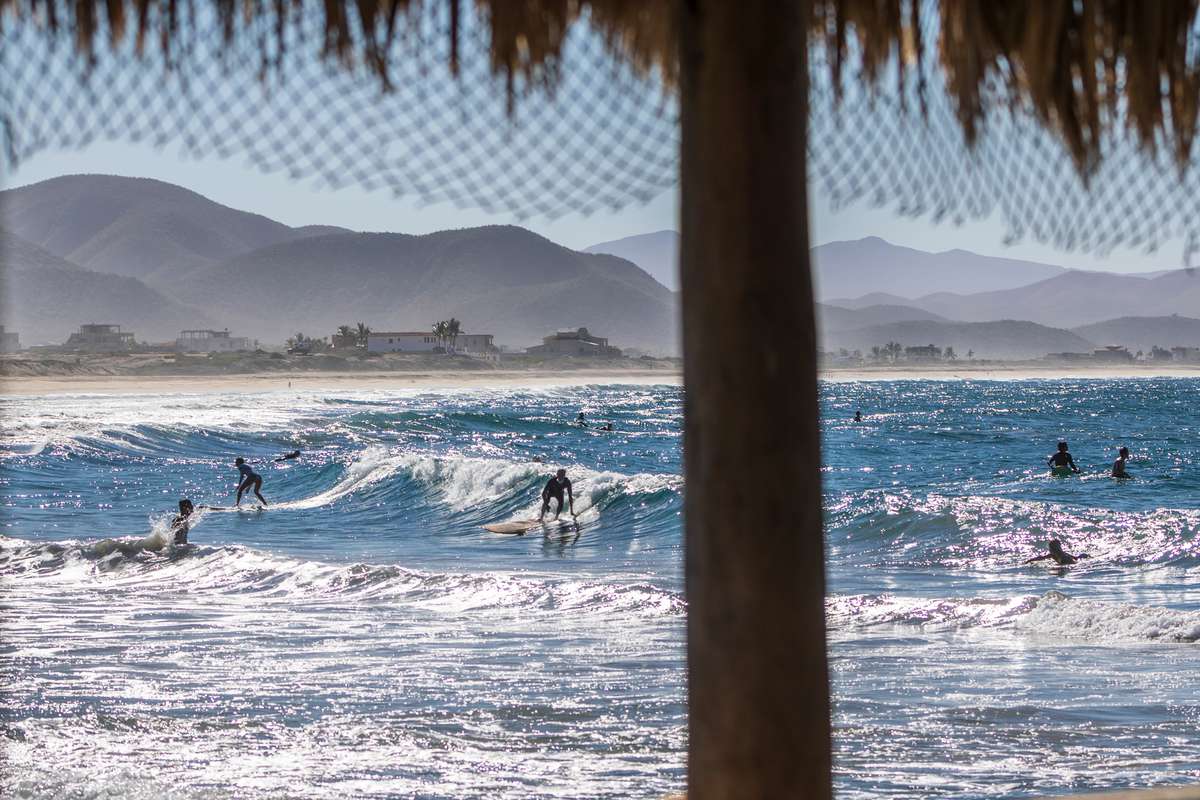 Surfers ride a wave at "Los Cerritos" beach as part of the sport activities practiced in the town of Todos Santos on February 5, 2021 in La Paz, Mexico.